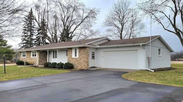 single story home featuring a garage and a front lawn