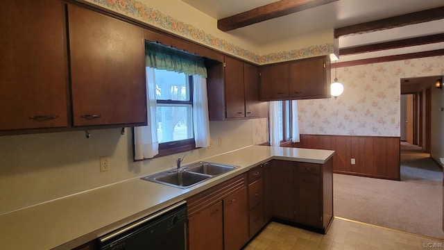 kitchen with kitchen peninsula, sink, beam ceiling, pendant lighting, and black dishwasher