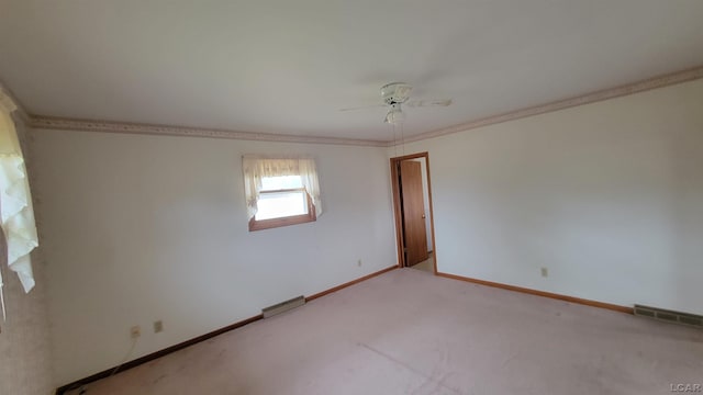 carpeted empty room with ceiling fan and ornamental molding