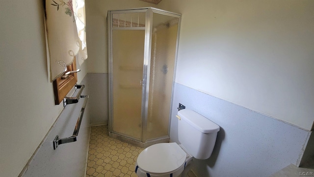 bathroom with a shower with shower door and toilet