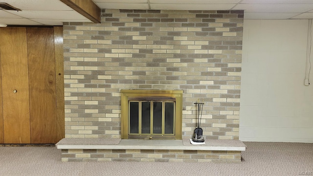 details featuring carpet floors, a drop ceiling, and wood walls