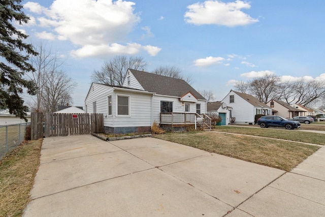 bungalow featuring a wooden deck and a front lawn