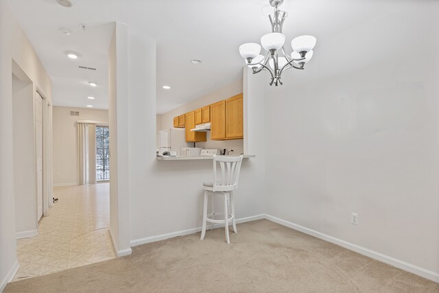 kitchen with light brown cabinets, white refrigerator, light colored carpet, a kitchen bar, and kitchen peninsula