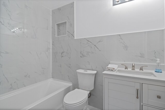 bathroom with vanity, toilet, tile walls, and a bathing tub