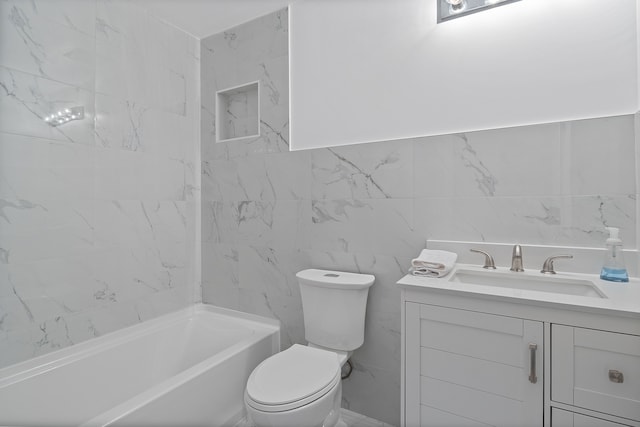 bathroom featuring toilet, vanity, tile walls, and a bathtub