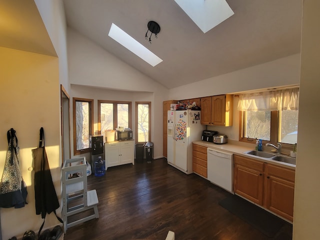 kitchen featuring dark hardwood / wood-style flooring, a skylight, white appliances, sink, and high vaulted ceiling