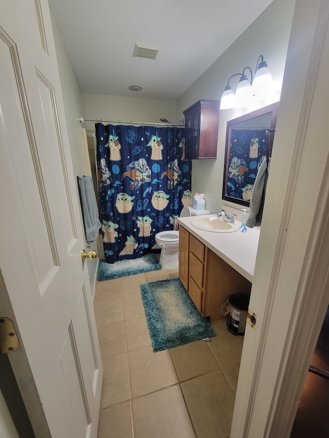 bathroom with tile patterned floors, vanity, toilet, and walk in shower