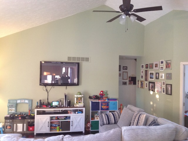 living room with ceiling fan and high vaulted ceiling