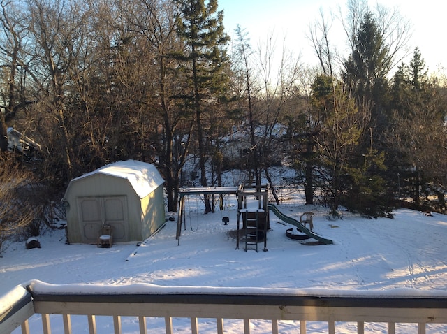 yard layered in snow featuring a storage unit