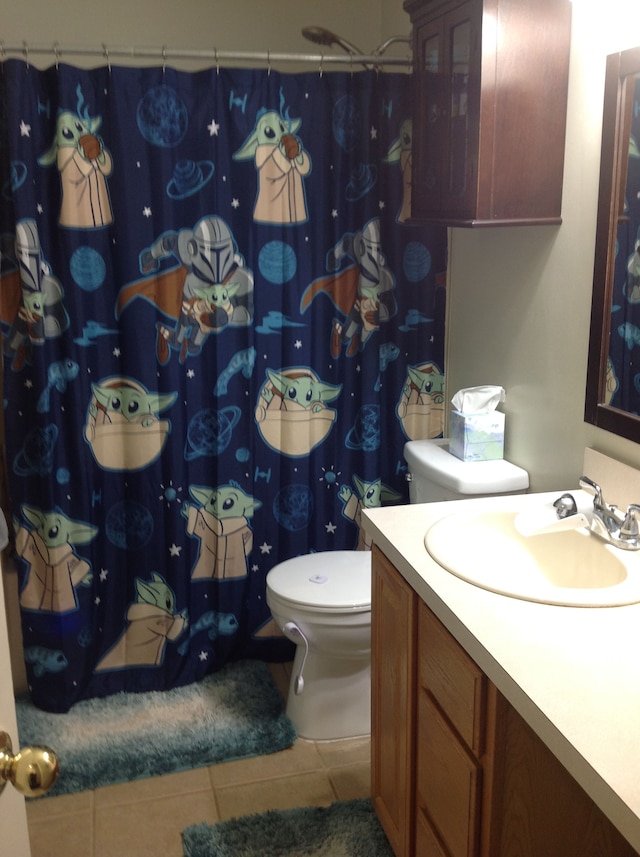 bathroom with tile patterned flooring, vanity, and toilet