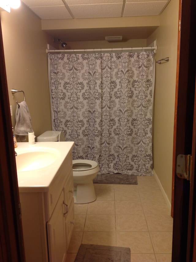 bathroom featuring tile patterned flooring, vanity, toilet, and walk in shower