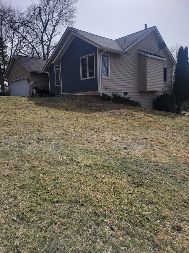 exterior space with a front yard, a garage, and roof with shingles