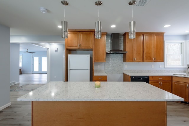 kitchen with wall chimney range hood, sink, a center island, light hardwood / wood-style floors, and white fridge