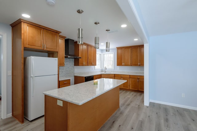 kitchen featuring pendant lighting, sink, white fridge, a center island, and wall chimney range hood