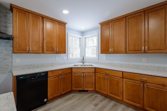 kitchen featuring dishwasher, light stone countertops, sink, and light wood-type flooring