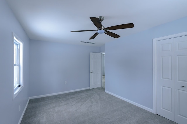 carpeted spare room with ceiling fan