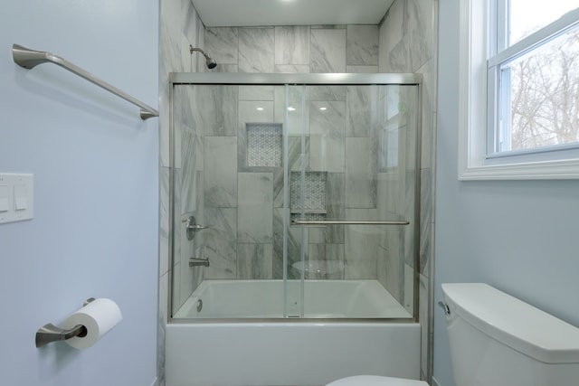 bathroom featuring enclosed tub / shower combo and toilet