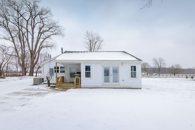 snow covered back of property with central air condition unit