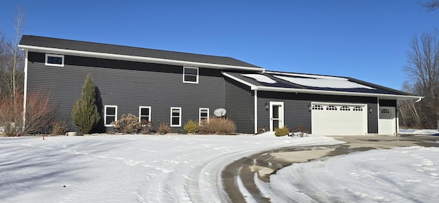 view of snow covered exterior featuring an attached garage