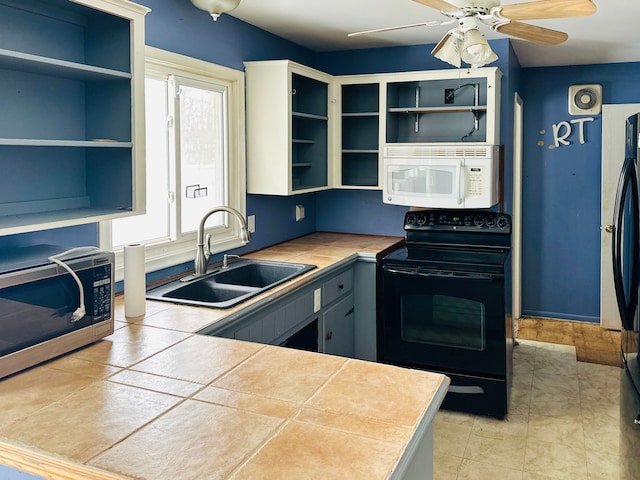 kitchen with tile countertops, refrigerator, black range with electric stovetop, sink, and ceiling fan