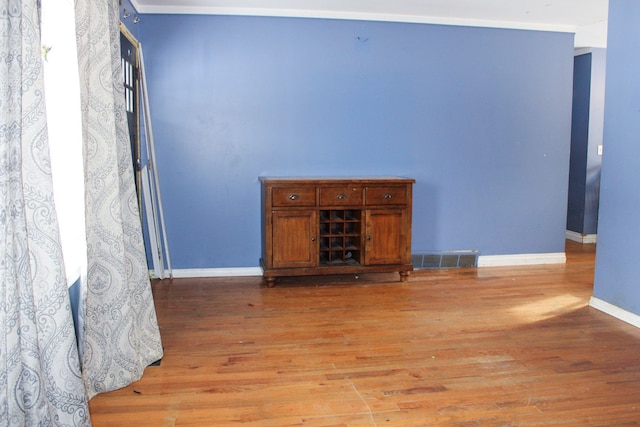 living room with light hardwood / wood-style floors and crown molding