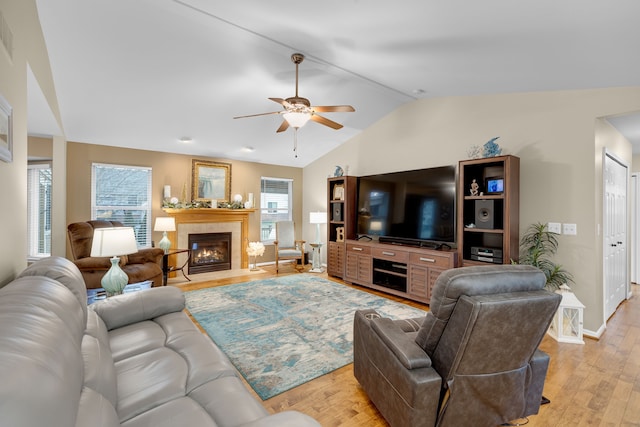 living room with ceiling fan, light wood-type flooring, and lofted ceiling