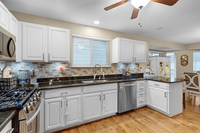 kitchen with sink, white cabinetry, kitchen peninsula, and appliances with stainless steel finishes