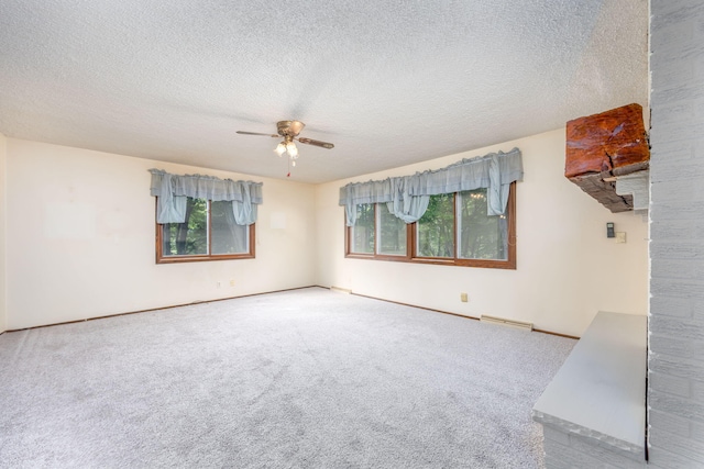 carpeted spare room with ceiling fan and a textured ceiling