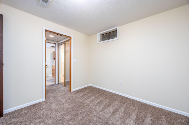 carpeted spare room featuring a textured ceiling