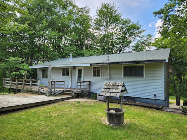 back of house featuring a wooden deck and a yard