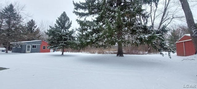 snowy yard featuring an outdoor structure