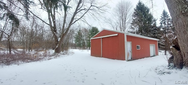 snow covered structure with a garage