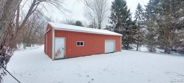 snow covered structure with a garage