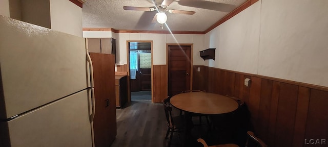 kitchen with white refrigerator, crown molding, ceiling fan, a textured ceiling, and dark hardwood / wood-style flooring