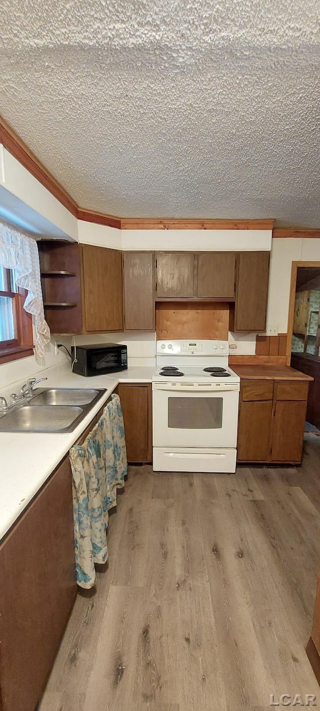 kitchen featuring a textured ceiling, light hardwood / wood-style floors, electric stove, and sink