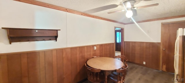 unfurnished room featuring wood-type flooring, a textured ceiling, ceiling fan, and ornamental molding