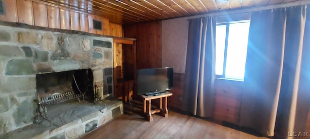 interior space featuring a fireplace, wood-type flooring, wood walls, and wood ceiling