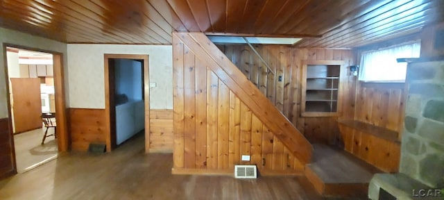 interior space with hardwood / wood-style flooring, wood walls, and wooden ceiling