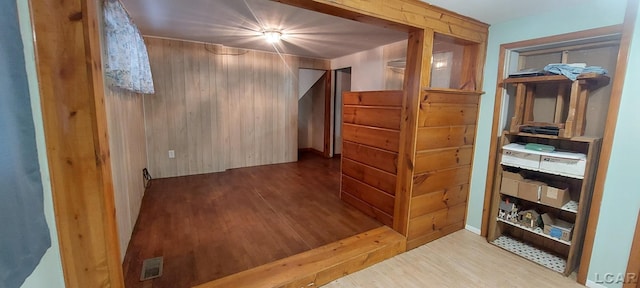 additional living space featuring wood walls and wood-type flooring