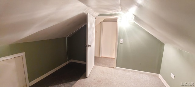 additional living space featuring light carpet and vaulted ceiling