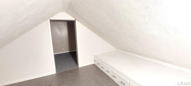 bonus room featuring lofted ceiling and a textured ceiling