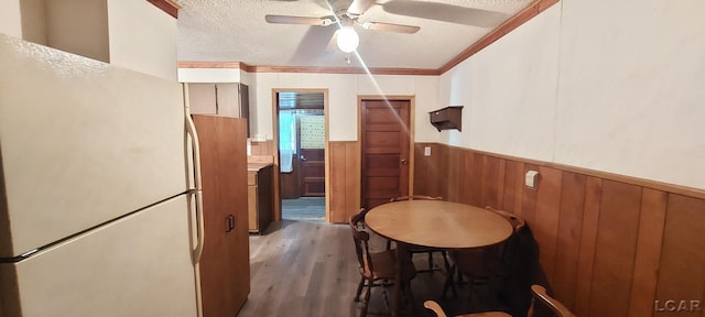 kitchen with ceiling fan, white refrigerator, crown molding, hardwood / wood-style floors, and a textured ceiling