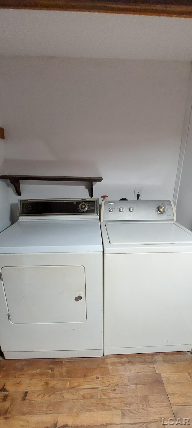 laundry area featuring light hardwood / wood-style flooring and washing machine and clothes dryer