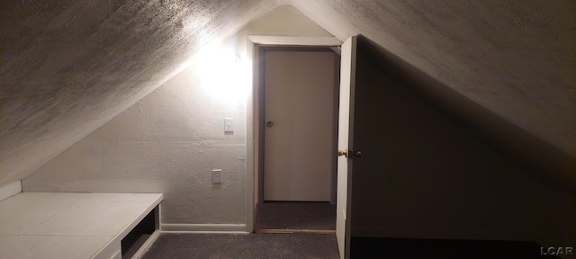 additional living space with a textured ceiling and lofted ceiling