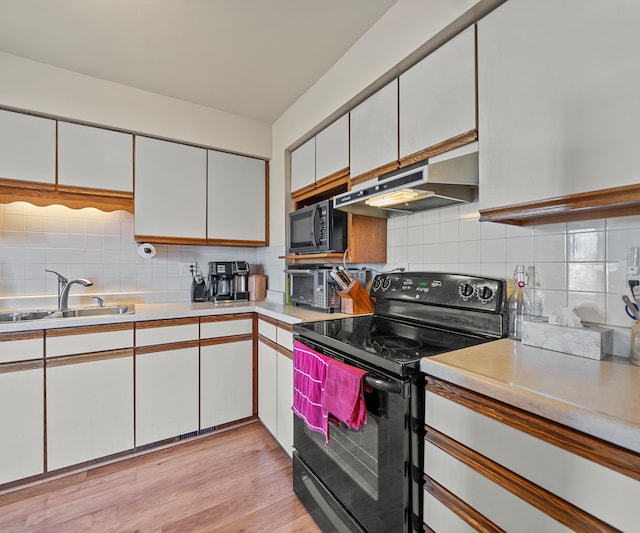 kitchen with white cabinetry, sink, light hardwood / wood-style flooring, backsplash, and black appliances