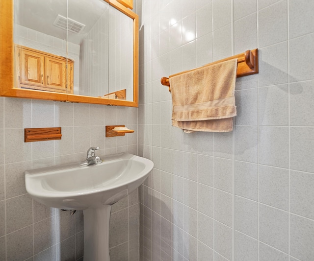 bathroom featuring decorative backsplash and tile walls