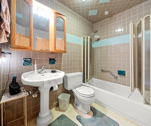 bathroom featuring tasteful backsplash, tiled shower / bath, tile walls, and toilet