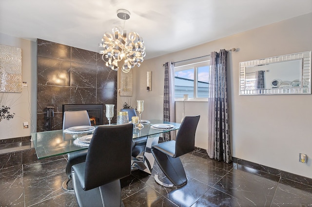 dining room featuring a fireplace and a notable chandelier