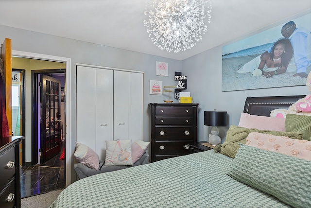 bedroom with a closet, a notable chandelier, and carpet floors