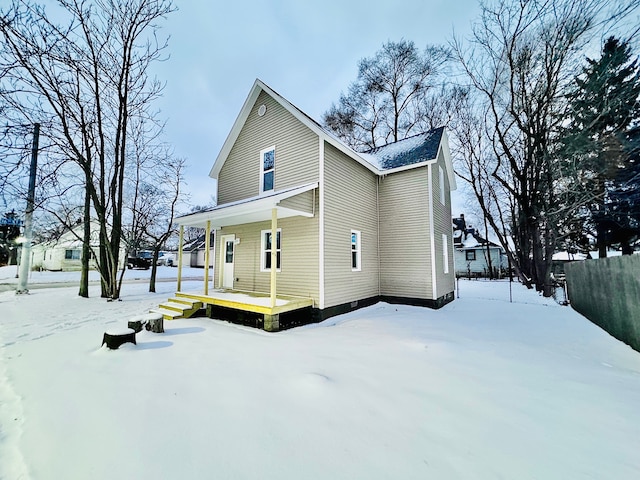 view of snow covered back of property